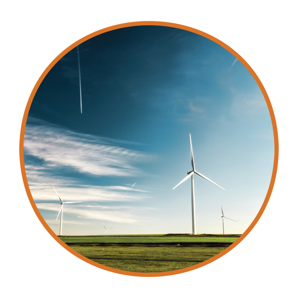 Three wind turbines in a grassy field against a blue sky with a few clouds