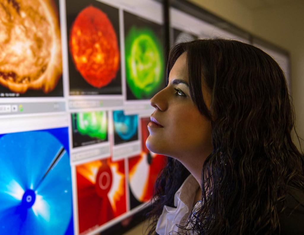 Professor analyzing colorful satellite images on a screen