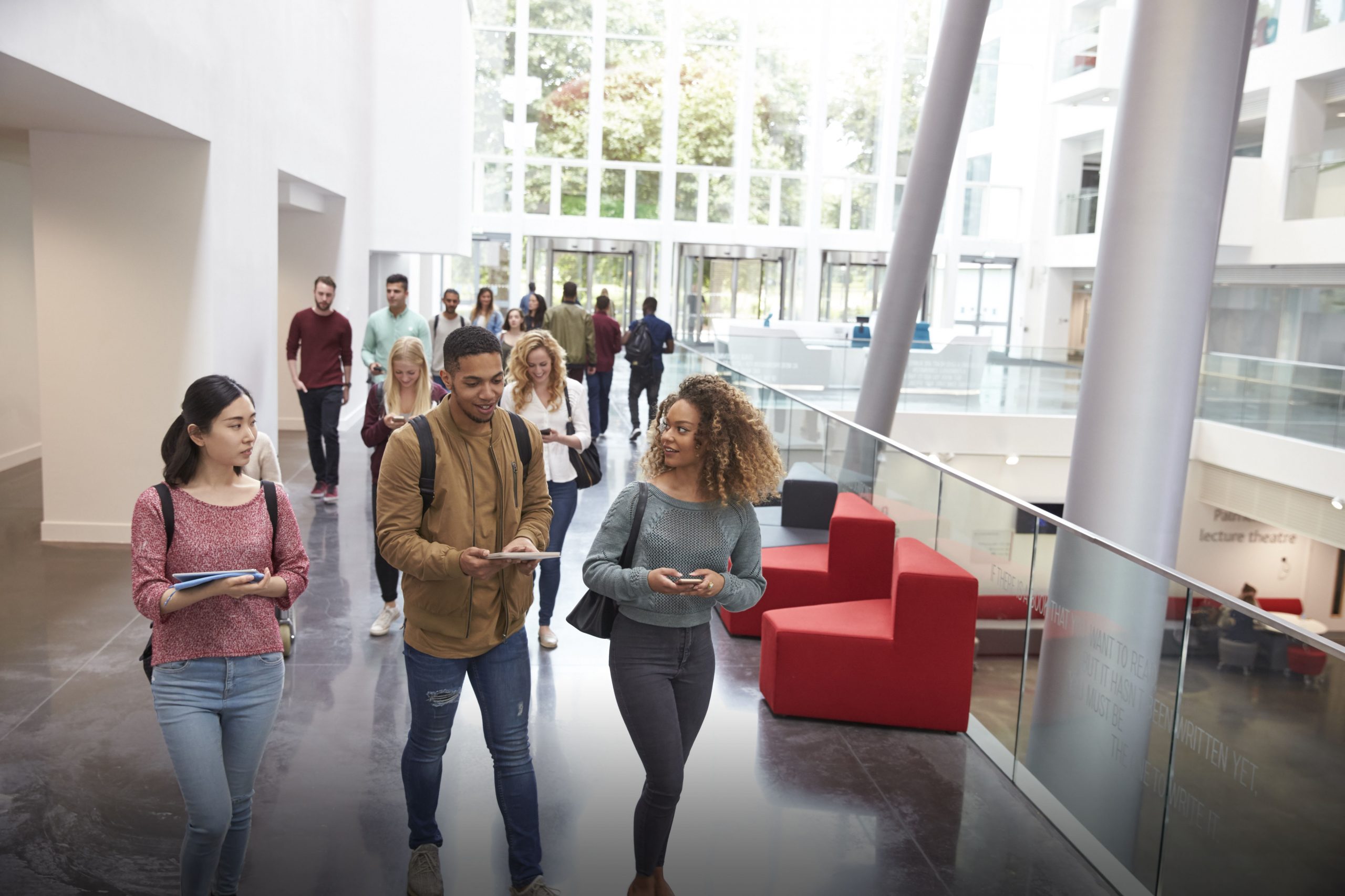 Students walk and talk using mobile devices in university