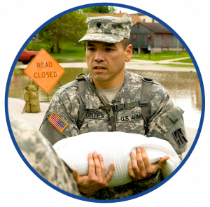 U S Army serviceman holding a sandbag, assisting in a flood area as part of disaster relief efforts