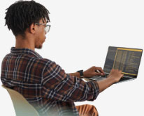 Unified Forecast System user seated in chair with open laptop running code.
